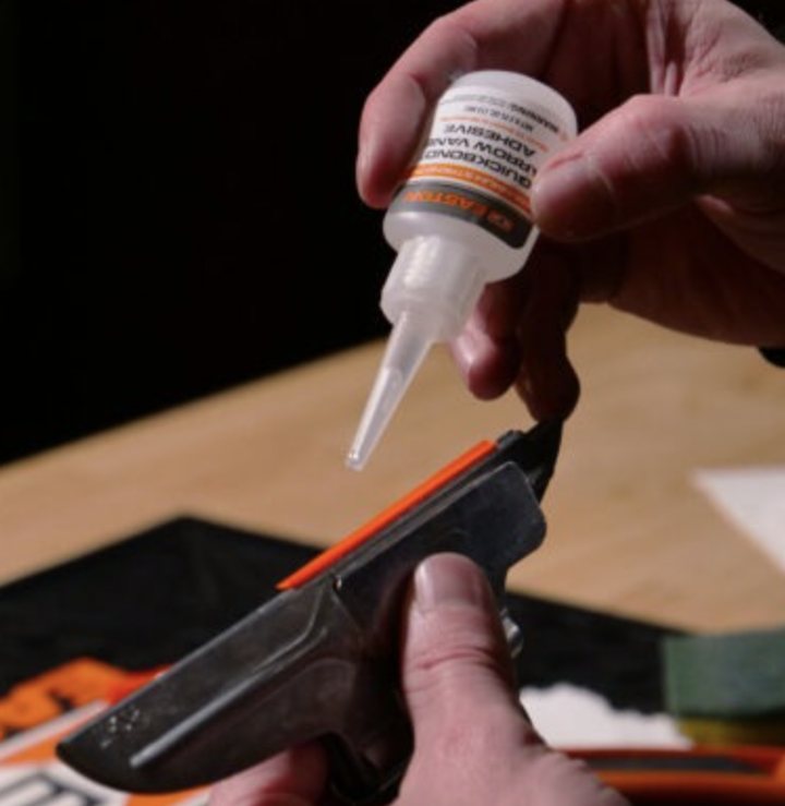 Running a bead of Easton Quickbond arrow vane adhesive along a vane clamped in a fletching jig