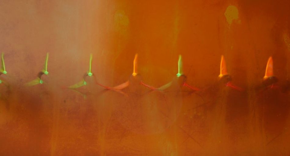 Long-exposure motion blur showing spinning vanes on a helical-fletched arrow in flight