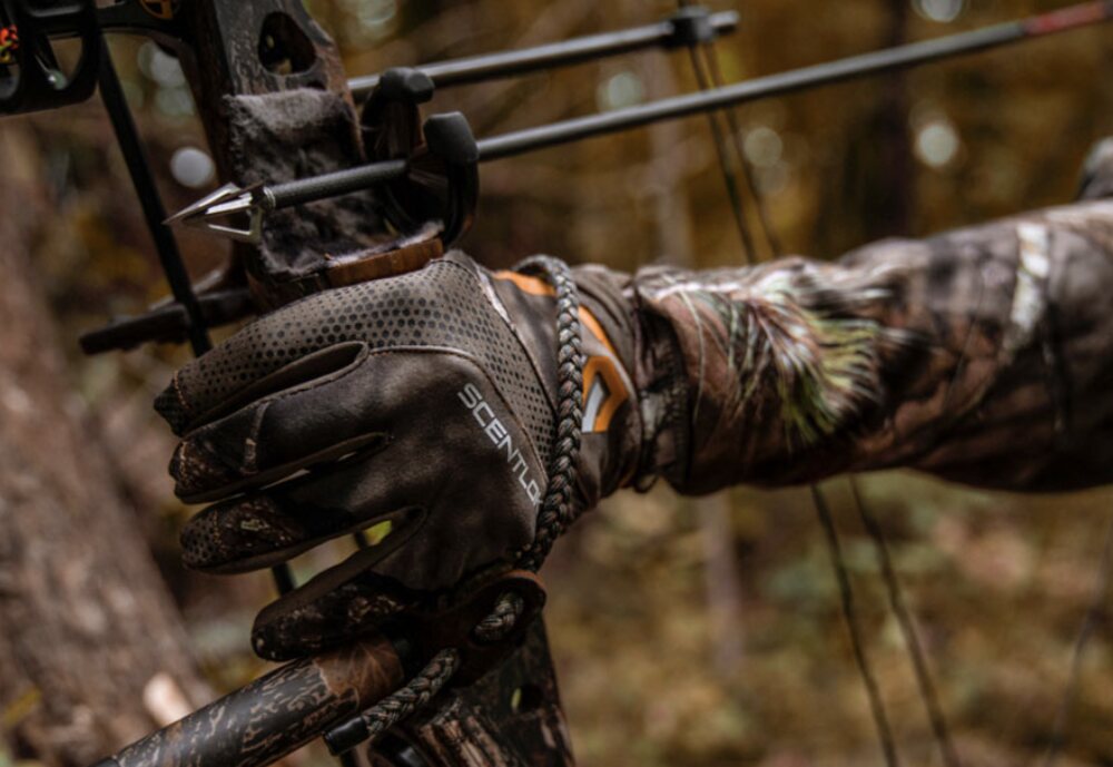 Bowhunter with a broadhead-tipped arrow nocked, ready to draw Bowhunter at full draw with a broadhead-tipped arrow nocked on a compound bow in the woods