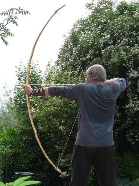 English Longbow — full draw Reenactor at full draw with an English longbow outdoors