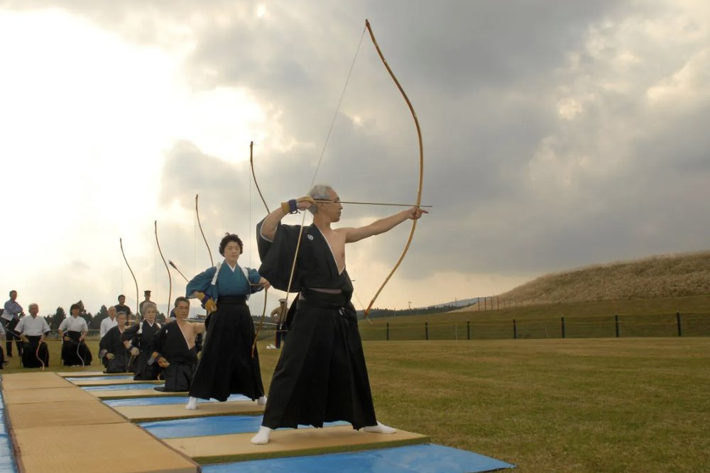 Kyudo Archers with the Yumi Kyudo archers in traditional dress drawing the asymmetric Japanese yumi
