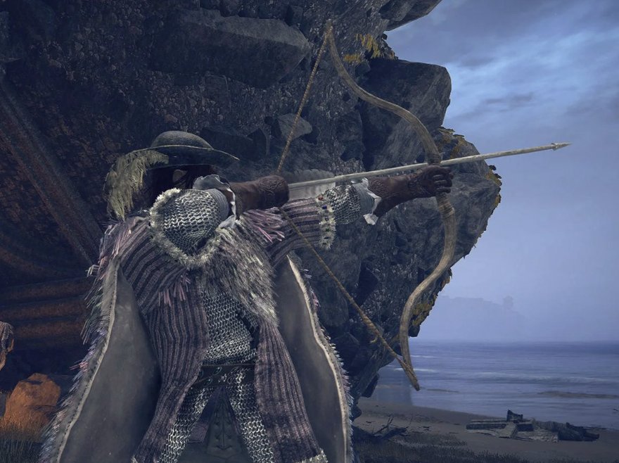 A cloaked archer aims a longbow toward the sea from a rocky cliff at dusk