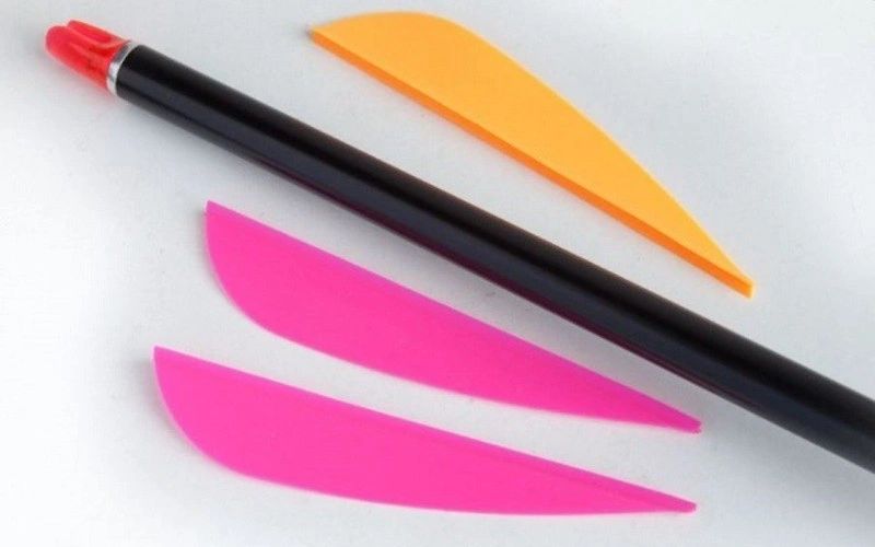 A black shaft beside orange and pink vanes curving in opposite directions A black shaft beside orange and pink vanes curving in opposite directions