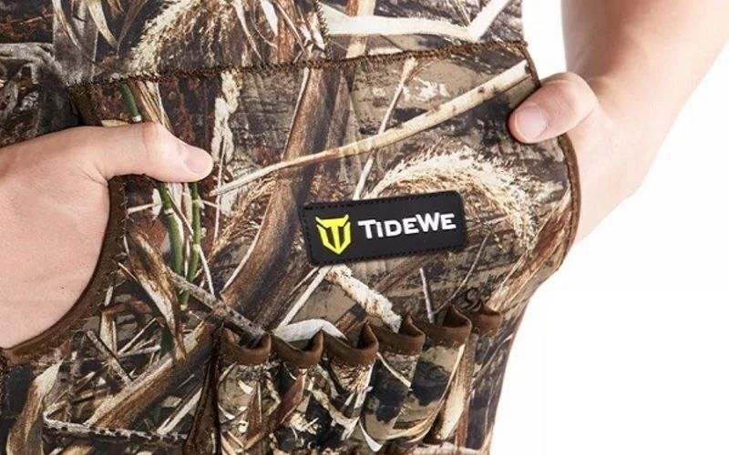 Hands holding open the front pocket of a camo TideWe chest wader